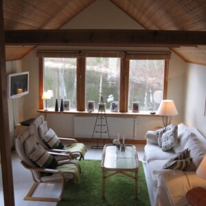 Hallen med halvtrappa ner till vardagsrummet och trappa upp till loftet